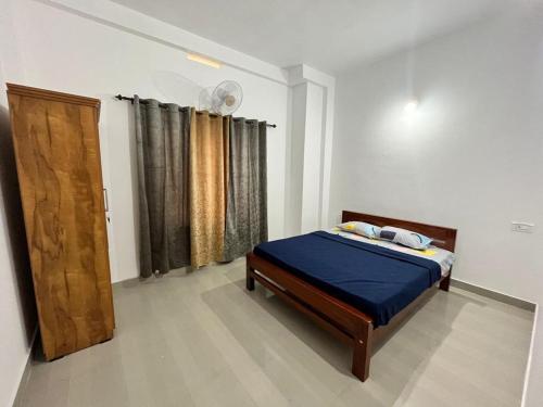 卡尔佩特塔Wayanad Biriyomz Residency, Kalpatta, Low Cost Rooms and Deluxe Apartment的一间卧室配有一张床和一扇木门