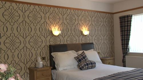 金洛赫利文高地逍遥游酒店的卧室配有一张床,墙上有两盏灯