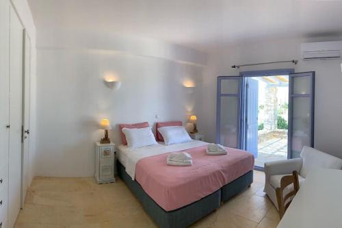 帕罗斯岛Villa Laugh, on The Limnes Beach的一间卧室配有一张带粉色毯子的大床
