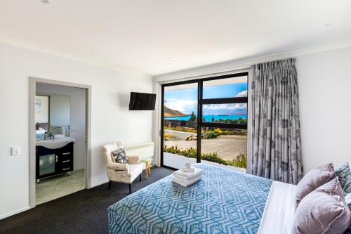 特卡波湖Roto View - Beautiful views of Lake Tekapo的一间卧室设有一张床和一个美景窗户。