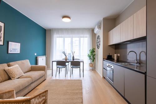 米兰Daplace - Portaluppi Apartment的厨房以及带沙发和桌子的客厅。