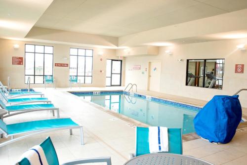 埃姆斯埃姆斯万豪广场套房酒店 的一个带蓝色桌椅的大型游泳池
