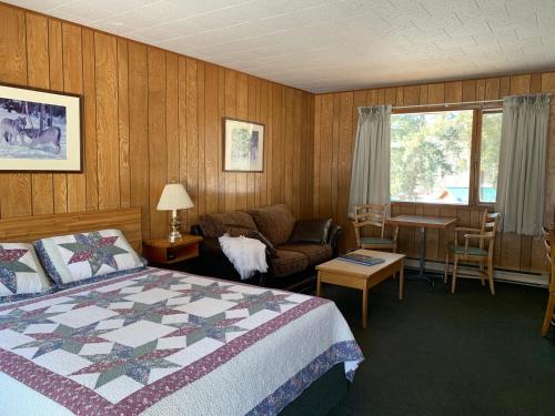 泰特若讷卡什泰特云庭山林小屋的一间卧室配有一张床、一张沙发和一张桌子