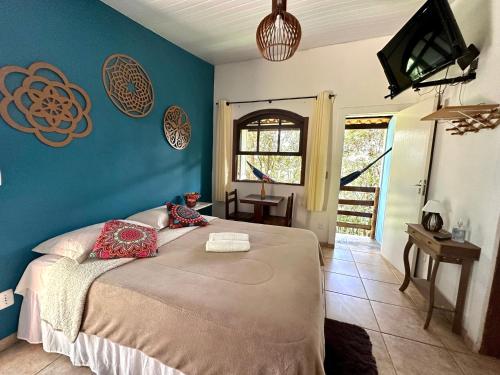 马卡科斯Sensorial Macacos的一间卧室设有一张床和蓝色的墙壁