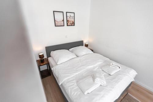 不来梅港Koje Sechs I Apartment im Zentrum mit Hafenblick的一张带白色床单和枕头的床