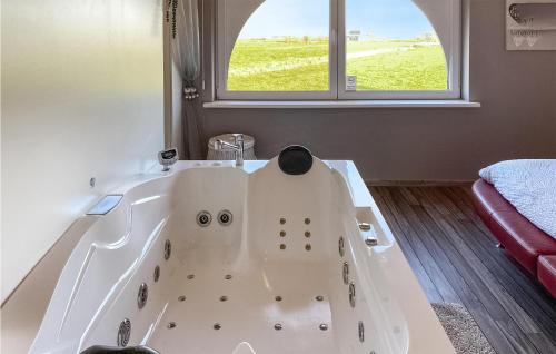 迪克斯梅德Awesome Home In Diksmuide With Wifi的窗户客房内的白色浴缸