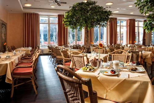 德累斯顿德勒斯顿艾尔贝弗伦萨酒店的用餐室配有桌椅和食物