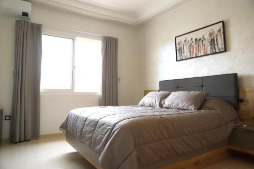 非斯Golf Royal appartement的一间卧室设有一张大床和窗户