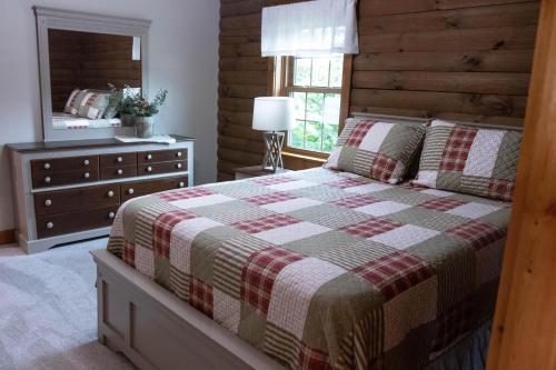 米勒斯堡Maple Leaf Cabin的一间卧室配有一张床、梳妆台和镜子