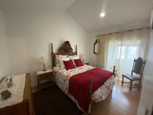 Casa dos Telhados的一间卧室配有一张带红色枕头的大床