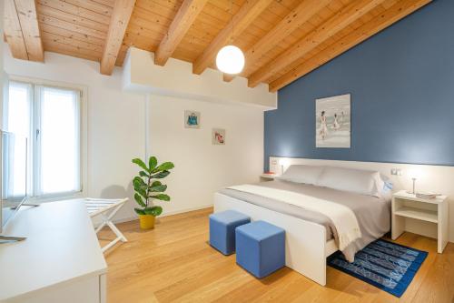 威尼斯Ca' Degli Antichi Giardini Apartments的一间卧室设有一张床和蓝色的墙壁