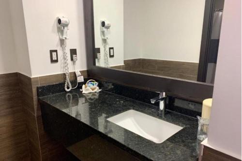 圣萨尔瓦多Beverly Hills: Hotel and Business的一个带水槽和电话的浴室台面