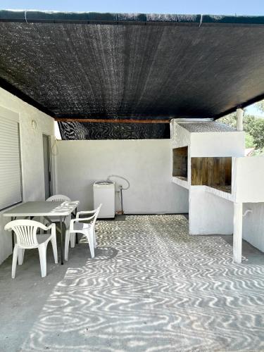 皮里亚波利斯Casa pet friendly, se reserva con seña的庭院配有白色的椅子、桌子和桌椅