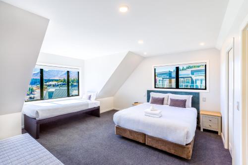 特卡波湖山景度假屋的带2扇窗户的客房内的2张床