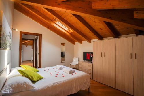塞斯托卡伦德[Ortensia PentHouse] Leonardo Academy, MXP & Laghi的卧室设有白色大床和木制天花板。