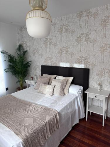 库迪列罗La Austera的一间卧室配有一张白色的床和黑色床头板