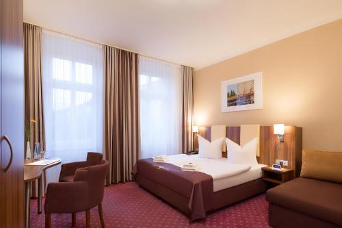 柏林金色酒店的配有一张床和一把椅子的酒店客房