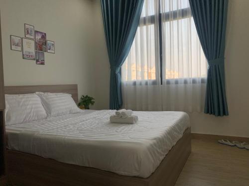 富国Liên’s Mini Hotel的一间卧室配有白色的床、蓝色窗帘和窗户