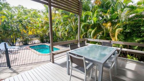 霍斯舒湾Dolphin Escape Holiday House的一个带桌椅的甲板和一个游泳池
