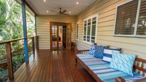 阿卡狄亚Tamarinds Beach House的门廊,房子上设有长凳