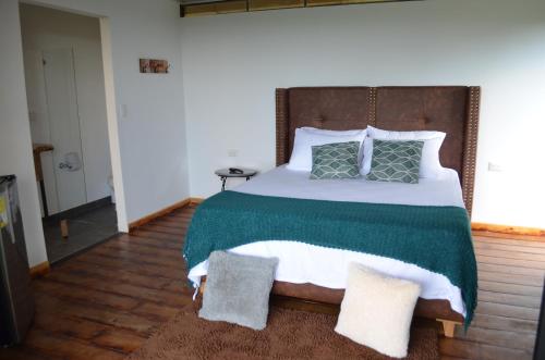 蒙特内哥罗GLAMPING CAFETOS的一间卧室配有一张大床,提供绿色和白色的毯子