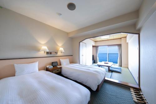 热海瑞斯尔皮亚阿塔米酒店的酒店客房设有两张床和大窗户。
