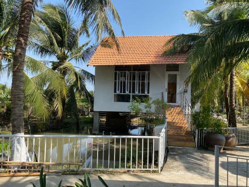 Thôn Tân HộiKhách sạn Ngọc Bích 2的白色围栏和棕榈树的房子