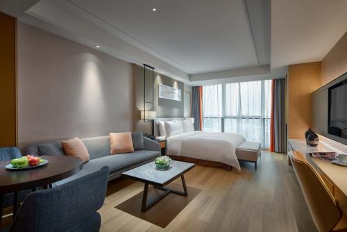 上海上海虹桥绿地铂瑞公寓的酒店客房设有一张沙发和一张床