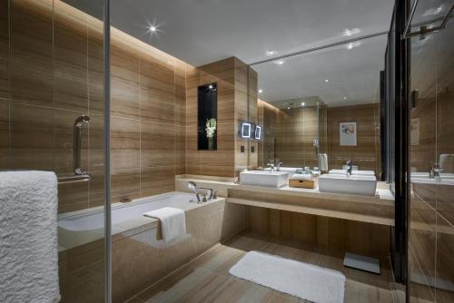 上海上海虹桥绿地铂瑞公寓的浴室配有两个盥洗盆和浴缸。
