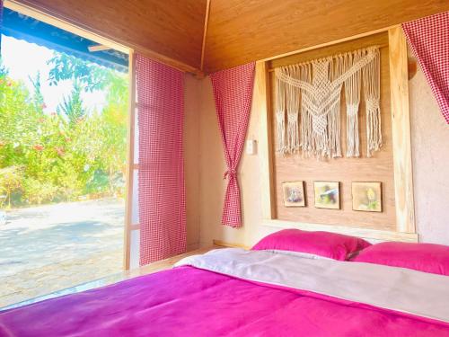 大叻Hoàng Gia Trang的一间卧室设有大窗户和一张粉红色床单