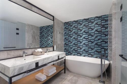 淮安淮安市中心万枫酒店的一间带浴缸和大镜子的浴室