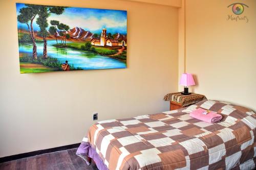 科帕卡巴纳solsticio hostel的卧室配有一张床,墙上挂有绘画作品