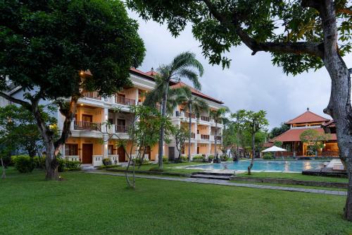 塞米亚克Kusuma Resort Seminyak的一个带游泳池和树木的度假胜地