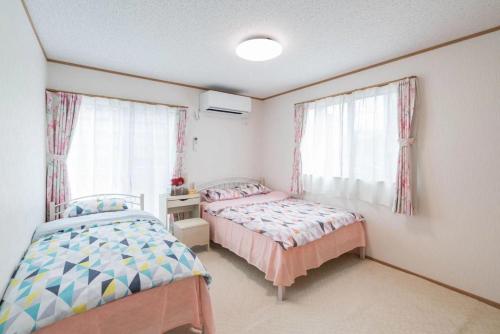 川口市Travel Palace Miyuki "Yomiuri Shimbun" - Vacation STAY 10239的一间卧室设有两张床和窗户。