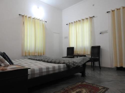 BijāpurJawai Leopard Villa的一间卧室配有床、两把椅子和窗帘