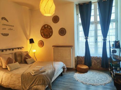 迪南Le Ty Rose的一间卧室配有一张带蓝色窗帘的大床