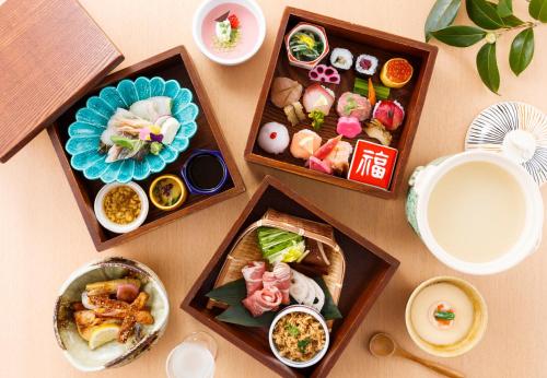加贺叶渡莉日式旅馆的一张桌子上面有三个木盒子,上面装满了食物