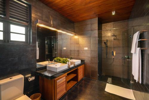 康提丁香别墅酒店的一间带两个盥洗盆和淋浴的浴室