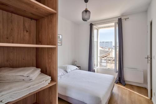 塞纳河畔伊夫里Cosy Residence Paris Sud的一间卧室设有一张床和一个大窗户