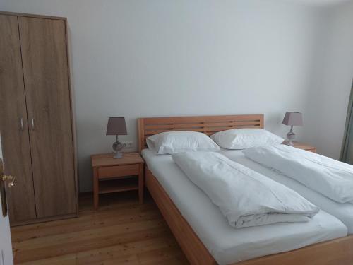 巴德米滕多夫Ferienwohnung Salzafeld的一间卧室配有带白色床单和枕头的床。