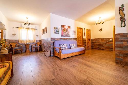 阿古伊梅斯Villa Paulito El Roque的一间铺有木地板的大客厅,配有蓝色的沙发