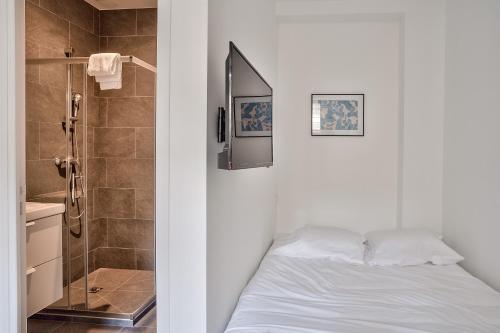 塞纳河畔伊夫里Cosy Residence Paris Sud的卧室配有白色的床和淋浴
