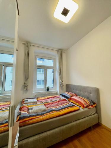 维也纳Deluxe Studio 3P TH的一间卧室设有两张床和两个窗户。