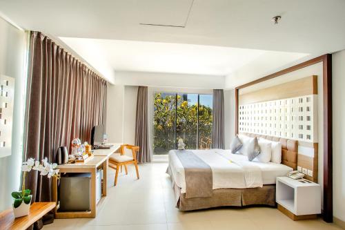 金巴兰普拉布金巴兰湾温泉度假村 的酒店客房设有一张大床和一张书桌。