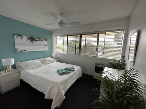 邦加里Our Beach House in Bribie Island的一间卧室设有一张床和一个大窗户