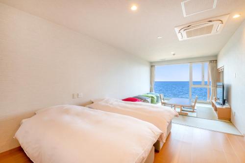 别府Umino Hotel Hajime - former Umikaoru Yado Hotel New Matsumi的一间带两张床的卧室,享有海景