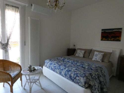 佩萨罗Casa LorEn的卧室配有床、椅子和窗户。