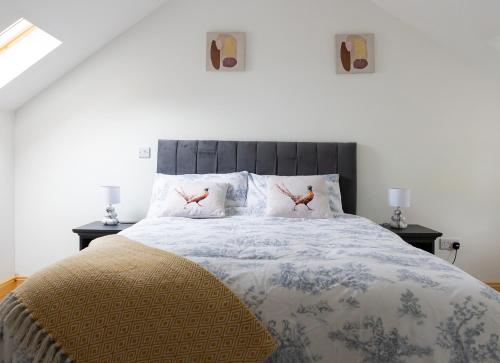 Shannon Castle Holiday Cottages Type B的一间卧室配有一张床铺,枕头上有两只鸟