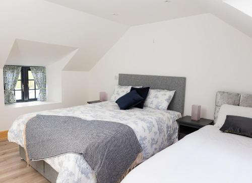 Shannon Castle Holiday Cottages Type C的一间白色卧室,配有两张床和窗户