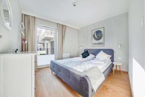 格但斯克Apartamenty Sun & Snow Angielska Grobla的一间卧室设有蓝色的床和窗户。